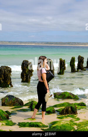 Jeune femme pagayer dans la mer à St Ives, Cornwall Banque D'Images