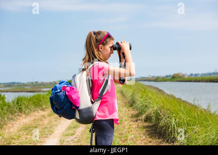 Girl le paysage à travers des jumelles Banque D'Images