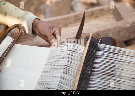 Une femme tisse une longue feuille de tissu sur un petit métier à main à Ban Phu Muang, au Laos. Banque D'Images