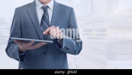 Digital composite of Businessman holding tablet en entrepôt lumineux Banque D'Images