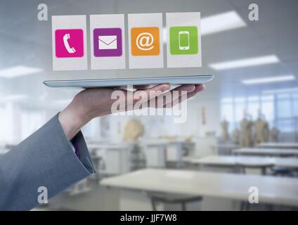 Digital composite of Businesswoman holding tablet apps avec des icônes dans l'usine d'atelier Banque D'Images