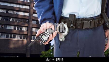 Digital composite de Midsection of security guard holding radio en ville Banque D'Images