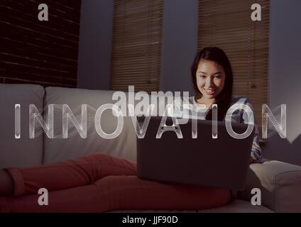 Composite de l'innovation numérique blanc texte et woman on couch with laptop Banque D'Images