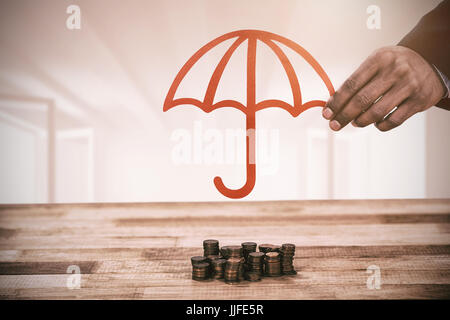 Main tenant un parapluie rouge contre blanc lumineux avec fenêtres ouvertes Banque D'Images