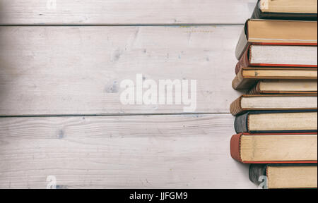 De vieux livres empilés sur fond de bois - copy space Banque D'Images