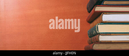 De vieux livres empilés sur fond de bois - copy space Banque D'Images