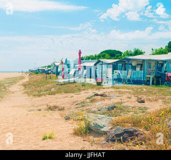 L'image traitée du camping sur la plage avec des tentes et des campeurs par mer Méditerranée aux beaux jours à Santa Susanna, Catalogne, Espagne Banque D'Images