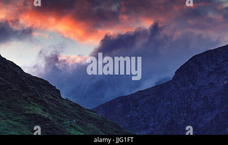 Spectaculaire coucher de soleil nuages colorés sur nant Gwynant Valley Hills dans la région de Snowdonia, UK Banque D'Images