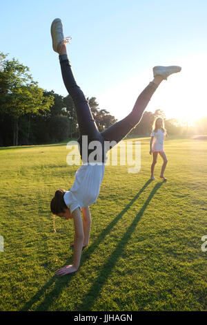 Une adolescente faisant un handstand vu par sa sœur. Banque D'Images