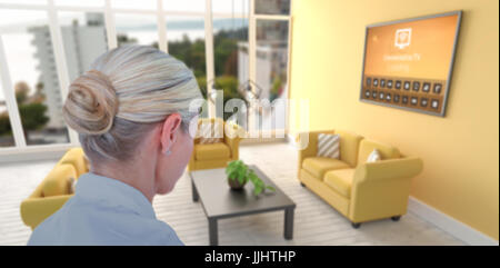 Vue arrière de businesswoman pointing contre l'image numérique de salon moderne Banque D'Images