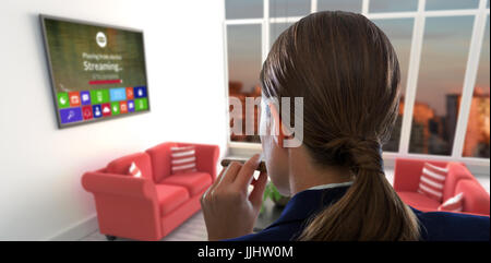 Vue arrière de businesswoman holding cigar contre canapés rouges dans la salle de séjour à maison moderne Banque D'Images