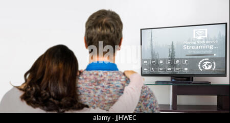 Vue arrière du couple standing contre diverses icônes de l'ordinateur avec une barre de progression Banque D'Images