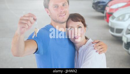 Couple Holding Keys avec des voitures Banque D'Images