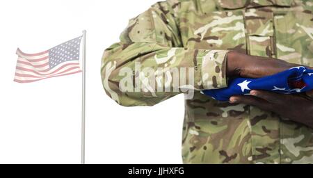 Soldat tenant le drapeau américain in front of white background Banque D'Images