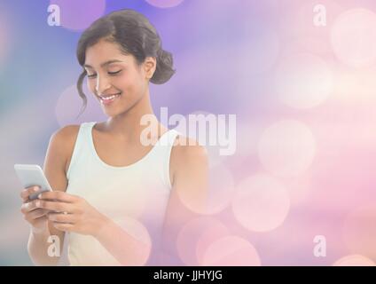 Smiling woman texting in lights Banque D'Images