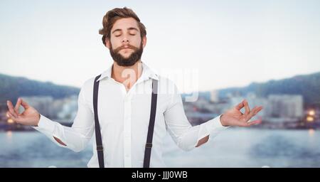 Man meditating millénaire contre l'horizon flou Banque D'Images