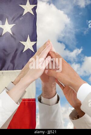 Hands High fiving contre drapeau américain Banque D'Images