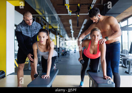 Les jeunes femmes en faisant des exercices de gymnastique avec les formateurs Banque D'Images