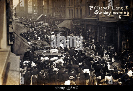 Marché Petticoat Lane, Wentworth Street, London au début des années 1900. Dimanche matin. Quartier juif, de nouveaux immigrants de l'Europe de l'Est. Les hommes portaient tous des Casquettes et chapeaux. East End. Carte postale. Banque D'Images