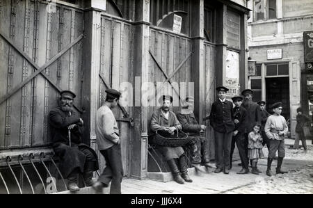 Russe / Polish shtetl ou village juif c. 1916-1917, les hommes et les garçons assis à l'extérieur du bâtiment. Porter des bottes et russe shirt Banque D'Images