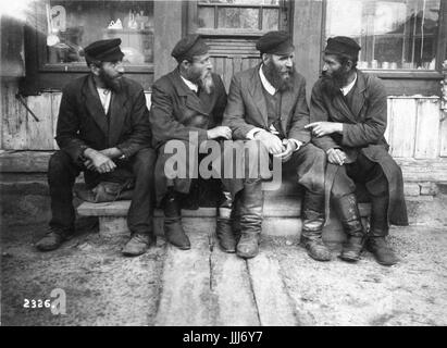 Krasilov, Ukraine (russe / Polonais shtetl ou village juif ).ch. 1916-1917. Les hommes juifs assis à l'extérieur de l'atelier de parler Banque D'Images