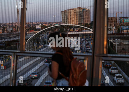 San Diego, Californie, USA. 19 juillet, 2017. Une femme marche à travers un pont surplombant l'autoroute 5 à proximité du port d'entrée de San Ysidro à San Diego, Californie. Toutes les voies sud de la frontière, les plus chargées de l'hémisphère ouest, sera fermé pour 57 heures dès le 23 septembre par le 25 septembre dans le cadre d'une phase finale pour la remise d'une partie de l'Interstate 5. Crédit : Joel Angel Juarez/ZUMA/Alamy Fil Live News Banque D'Images