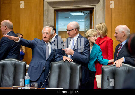 Le sénateur américain Bob Corker (républicain du Tennessee), président, Comité du Sénat américain sur les relations étrangères, à gauche, des gestes vers la table des témoins pour Robert Wood Johnson (Woody) IV, Ambassadeur désigné des États-Unis d'Amérique pour le Royaume-Uni de Grande-Bretagne et d'Irlande, comme l'ancien sénateur Kay Bailey Hutchison (républicain du Texas), Représentant Permanent des Etats-Unis désigné sur le Conseil de l'Organisation du Traité de l'Atlantique Nord (OTAN), avec le rang et le statut de l'Ambassadeur parle avec nous le sénateur Ben Cardin (démocrate du Maryland), Rang qu'ils comme ils Banque D'Images