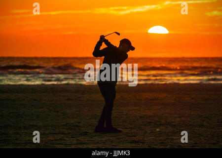 Coucher de soleil sur Southport, Merseyside, 20 juillet 2017. Météo britannique. Quatorze ans passionné de golf 'Michael Carson' a été inspiré par la 146e Open Championship détenu à la célèbre Royal Birkdale 'course' dans sa ville natale de Southport Merseyside. Après avoir vu jouer à la télévision d'aujourd'hui, Mike ne pouvait pas attendre de balles de golf ping dans le coucher du soleil près de la côte nord ouest. Credit : Cernan Elias/Alamy Live News Banque D'Images