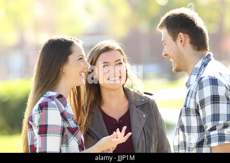 Trois amis heureux parler et rire ensemble dans la rue Banque D'Images