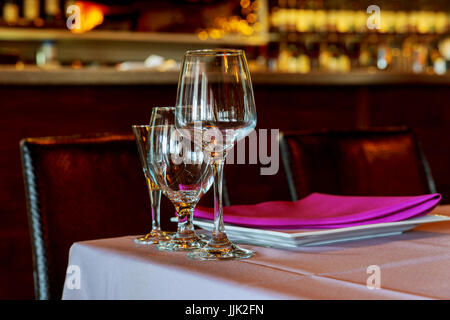 Belle table avec de la vaisselle et des fleurs pour une fête, réception de mariage ou autre événement festif. Verres et couverts pour événement diner Banque D'Images