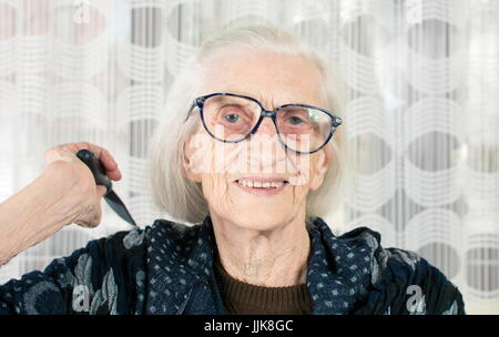 Senior woman holding un peigne à la maison Banque D'Images