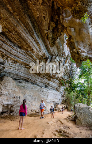 Les randonneurs en vertu de falaise de calcaire sur la piste vers SALTO DE CABURNI situé à l'Topes de Collantes dans les montagnes de la sierra del Escambray - CUBA Banque D'Images