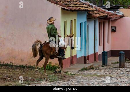 Les chevaux et les cowboys sont un site commun sur les rues pavées de Trinidad, Cuba Banque D'Images