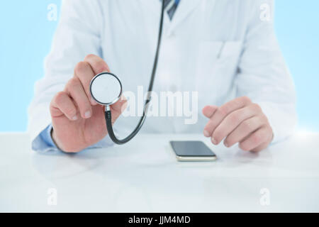 Image 3D composite de midsection of doctor holding stethoscope Banque D'Images