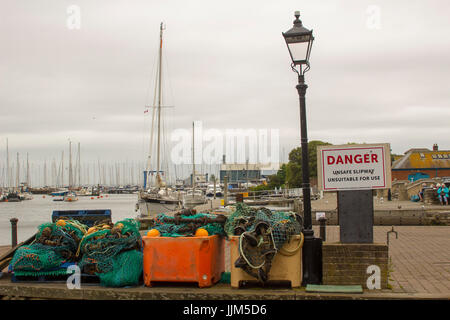 Filets de pêche commerciale stocké dans une pile à côté d'une lampe de rue sur le quai au port de Lymington dans le Hampshire, sur la côte sud de l'Angleterre Banque D'Images