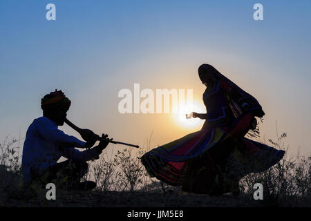 Silhouette d'une femme gitane danse une danse traditionnelle de la musique d'un musicien, Pushkar, Rajasthan, India Banque D'Images