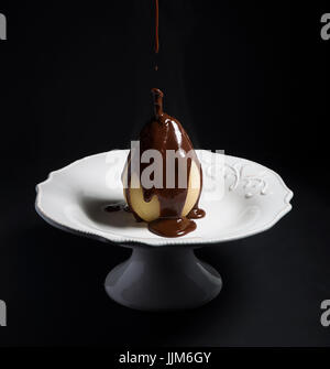 Poire Pochée dans une sauce au chocolat Banque D'Images