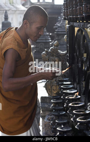 Katmandou, Népal. Les lampes des feux de moine bouddhiste au Temple de Swayambhunath. Banque D'Images