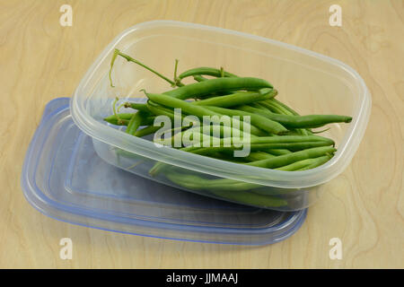 Haricots verts crus dans du plastique réfrigérateur coffre de rangement Banque D'Images