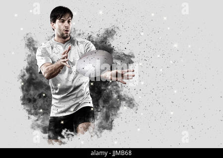 Joueur de rugby avec un uniforme blanc qui sort d'une explosion de fumée . Banque D'Images