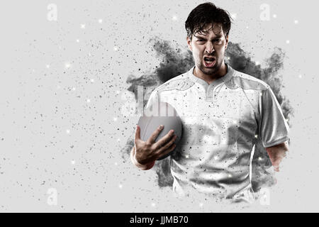 Joueur de rugby avec un uniforme blanc qui sort d'une explosion de fumée . Banque D'Images