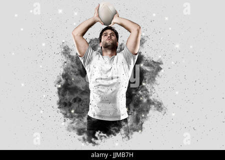 Joueur de rugby avec un uniforme blanc qui sort d'une explosion de fumée . Banque D'Images