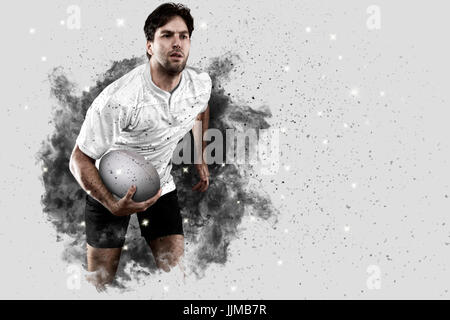 Joueur de rugby avec un uniforme blanc qui sort d'une explosion de fumée . Banque D'Images