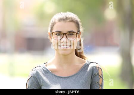 Portrait d'une jeune fille portant des lunettes à l'extérieur à vous dans un parc Banque D'Images