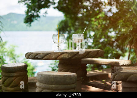 Table en pierre avec deux verres à boire sur l'arrière-plan flou beach resort Banque D'Images