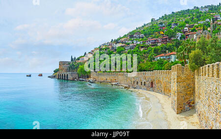 La ligne de la plage de sable fin à la forteresse médiévale mur le long de la colline du Château d'Alanya, Turquie sur la péninsule. Banque D'Images