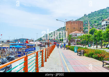 ALANYA, TURQUIE - 9 mai 2017 : La promenade quotidienne le long de la promenade de bord de Deco avec aview sur navires de tourisme, bateaux de pêche et la Tour Rouge à l'avant Banque D'Images