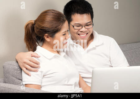 Asian couple relaxing on couch Banque D'Images