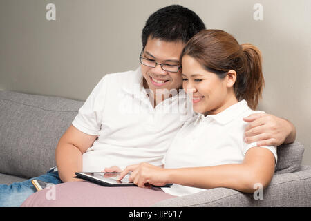 Asian couple relaxing on couch Banque D'Images