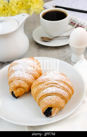 Les croissants avec garniture au chocolat tasse et le café du matin frais. Banque D'Images